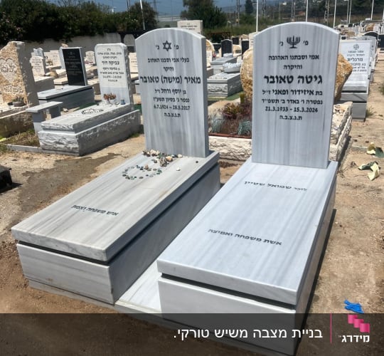 שני מצבות שיש עם כיתוב בעברית בבית קברות